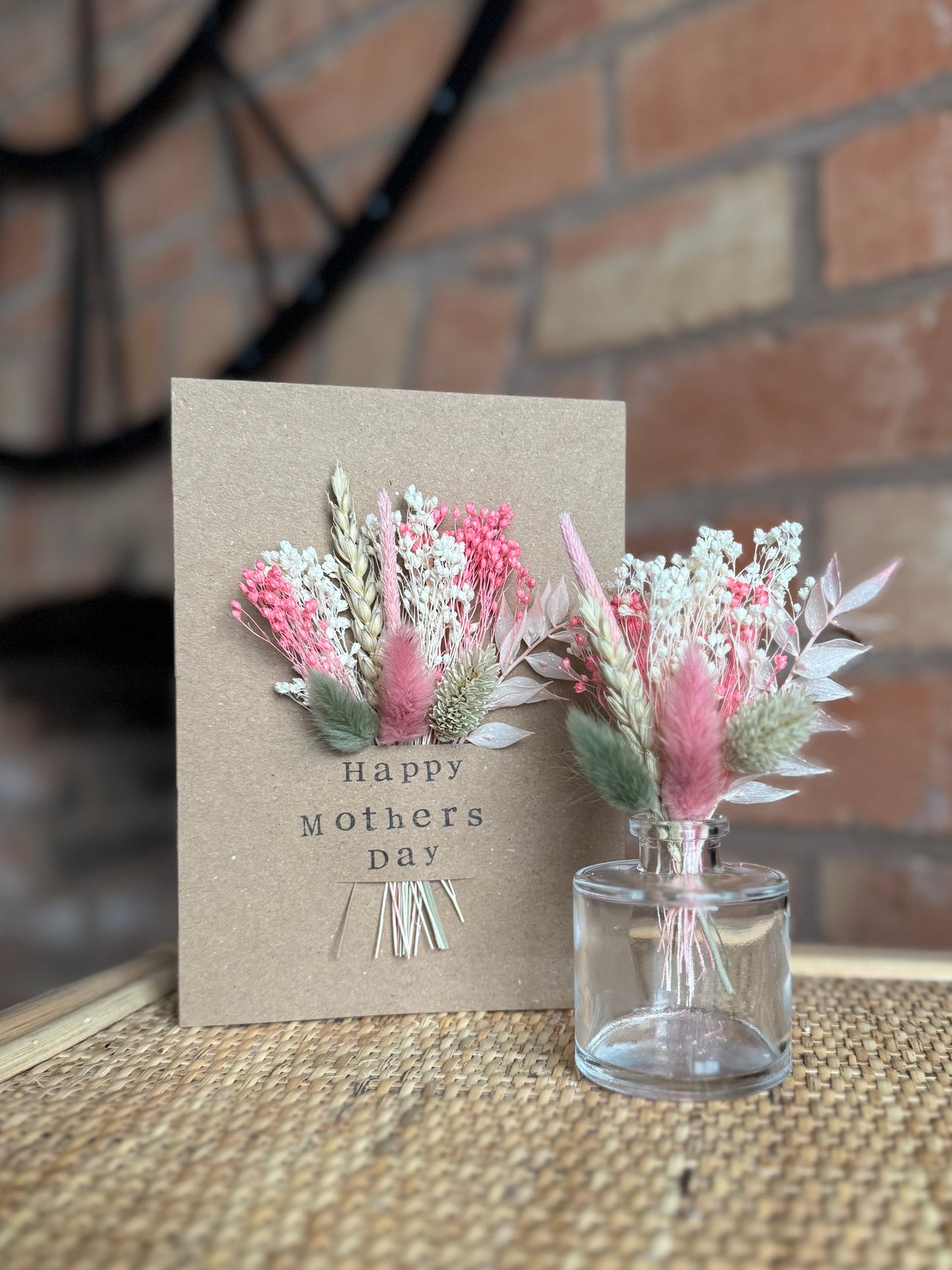 Dried flower card displayed on rattan shelf, in celebration of Mother’s Day. A small mini vase is displayed alongside to show its purpose of the removable flowers