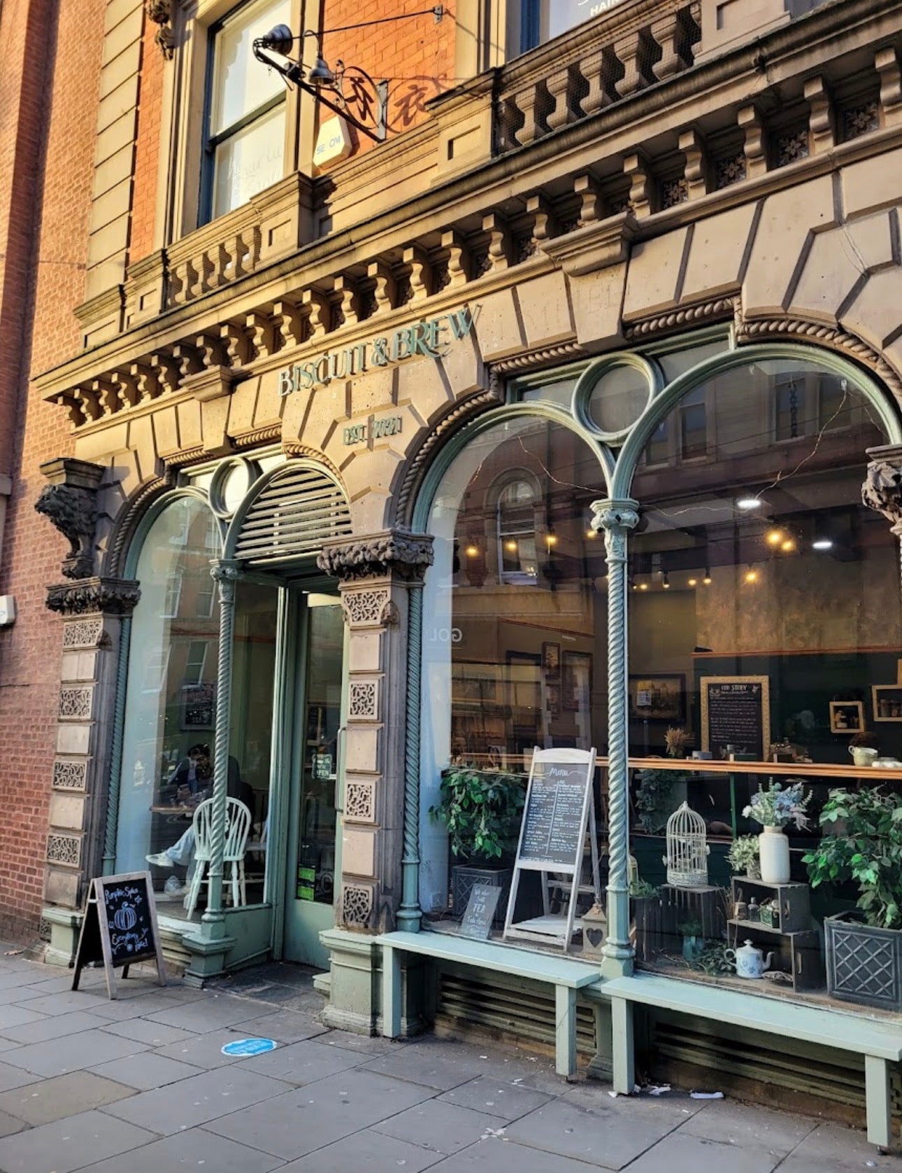 Vintage storefront with decorative elements and a sign on a brick building.