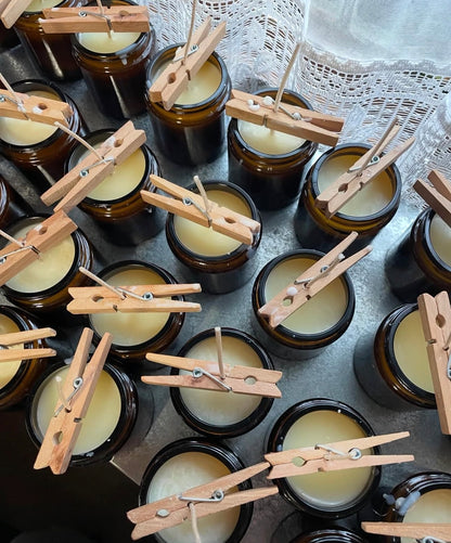 Jars of candles with wooden clothespins on a textured surface