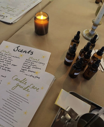 Bottle caps, a candle, and a document on a table with a warm glow.