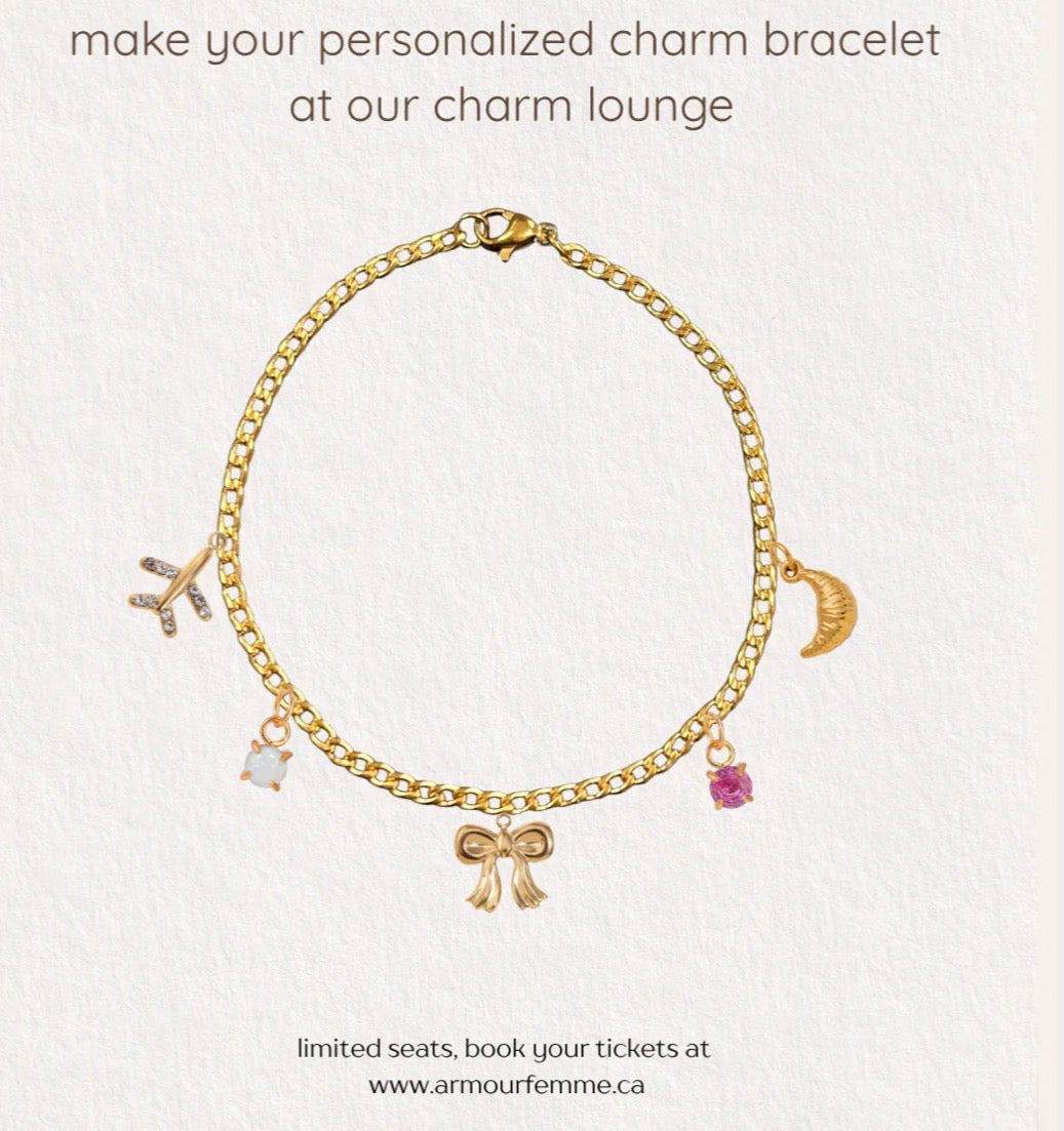 Gold charm bracelet with various charms on a light gray background
