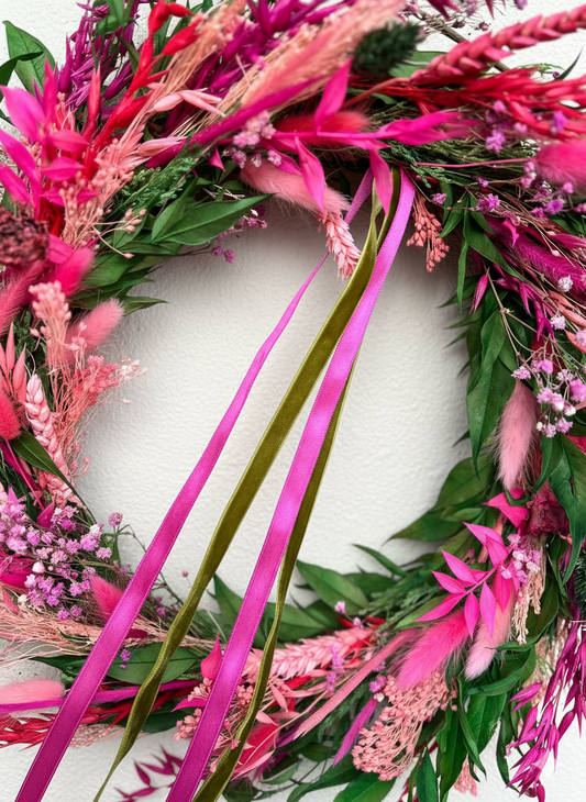 Decorative wreath with pink and green elements on a white background