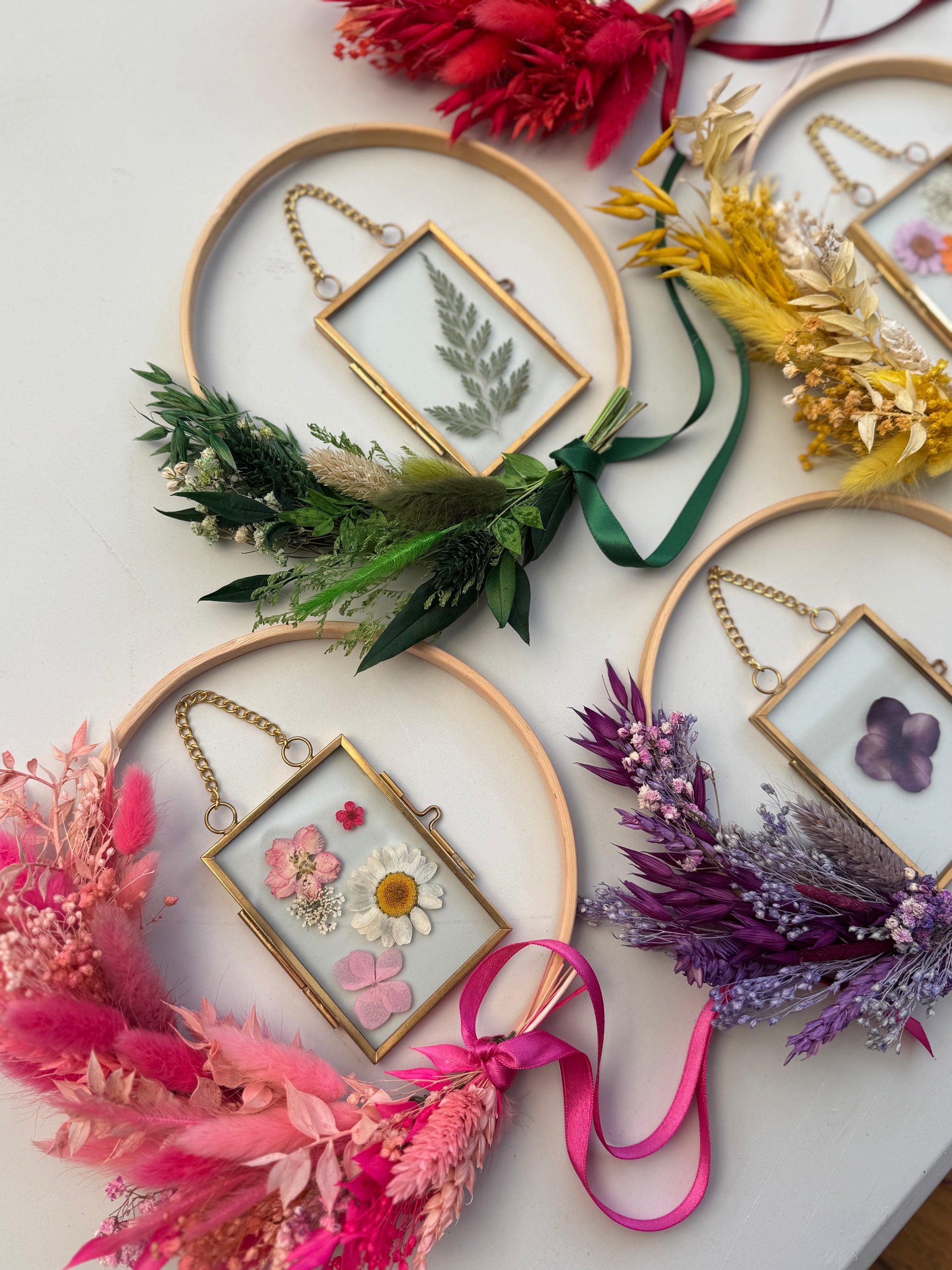 Decorative gold frames with pressed flowers and ribbons on a light background