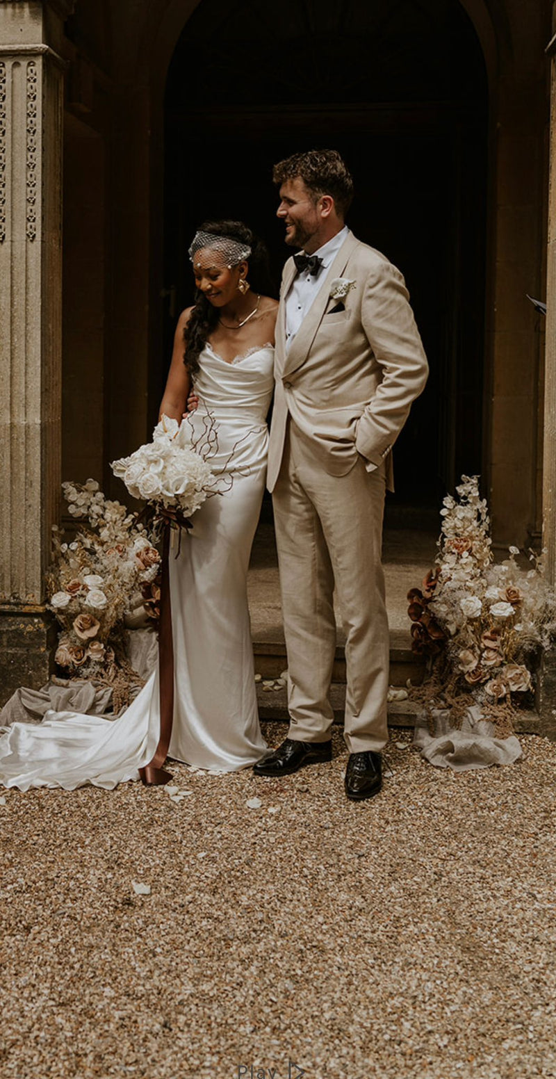 Wedding couple standing together in an elegant outdoor setting with floral arrangements.